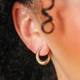 Close Up of Illusion Swirl Hoop Earrings in Gold on Model