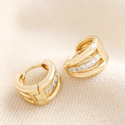 Triple Illusion Crystal Huggie Hoop Earrings in Gold on Model Triple Illusion Crystal Huggie Hoop Earrings in Gold Against Beige Background