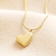 A chunky heart pendant necklace in gold.