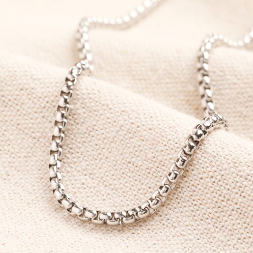 Men's Stainless Steel Box Chain Against Beige Backgrounf A box chain necklace made from stainless steel