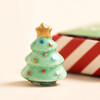 Close Up of Tiny Matchbox Ceramic Christmas Tree Token on Beige Background