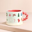 The festive mug with candlycane handle on a beige background