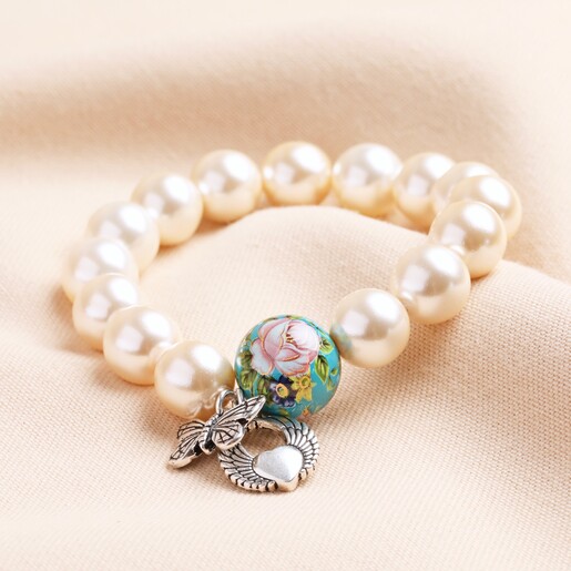 Large 20th Anniversary Pearl Charm Bracelet With Silver Charms on Neutral Fabric