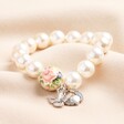 Large 20th Anniversary Pearl Charm Bracelet With Silver Charms on Beige Fabric