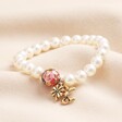 Small 20th Anniversary Pearl Charm Bracelet with Gold Charms on Beige Fabric