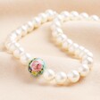 Small 20th Anniversary Pearl Necklace With Green Tensha Bead on Beige Fabric