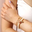 Model Wears Small 20th Anniversary Pearl Charm Bracelet With Other Gold Bracelets