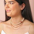 Small 20th Anniversary Pearl Necklace Layered With Other Necklaces on Dark Haired Model