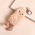 Jellycat Amuseables Peanut Bag Charm on a Beige Background