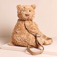 A Cuddly Teddy Bear Rucksack Sitting on a Neutral Surface