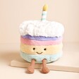 Jellycat Amuseable Rainbow Birthday Cake Soft Toy on a Beige Background