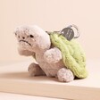 A grumpy turtle bag charm with a grey body and a green shell