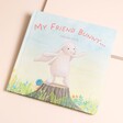 Jellycat My Friend Bunny Book front cover featuring pink text and a white rabbit standing on a log