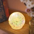 A sparkling night light with glitter in a round ball shape,