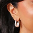 Close Up of Tapered Oval Hoop Earrings in Silver on Model