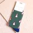 A dark green pair of socks with a repeating penguin pattern