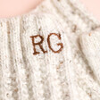 Close up of personalisation on Personalised Embroidered Knitted Hand Warmers in Marled Cream