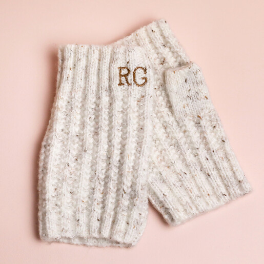 Personalised Embroidered Knitted Hand Warmers in Marled Cream Personalised Embroidered Knitted Hand Warmers in Marled Cream laid out on pink coloured background