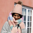 Model Wearing Pink Cable Knit Pom Pom Bobble Hat With Pink and Blue Stripe Scarf