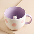 Sass & Belle Mojave Hidden Cat Mug with purple inner, a white cat and a polka dot pink exterior