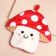 A happy smiling red toadstool shaped hot water bottle