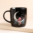 Black Glazed Ceramic Mug With Crescent Moon and Woodland Emblem on a Neutral Background