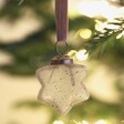 Hanging Star Decoration on a Christmas tree adorned with fairy lights