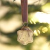 Mini Star Hanging Decoration on a Christmas Tree adorned with fairy lights