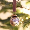 Silver and Gold Mini Bauble on a festive Christmas tree background