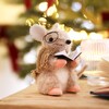 A Small Furry Mouse Ornament Decorated With Glasses, a Scarf and Holding a Carol Book, Sitting Amongst a Seasonal Display