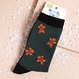 A pair of green mens socks with ginger bread men pattern