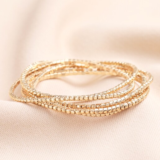 A set of five gold bracelets that can be worn individually or together as a stack