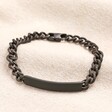 A chunky trace chain bracelet with a long, curved bar plaque in black.