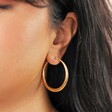 Close Up of Stainless Steel Large Tapered Hoops in Gold on Model