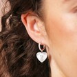 Close Up of Sunbeam Heart Huggie Hoop Earrings in Silver on Model