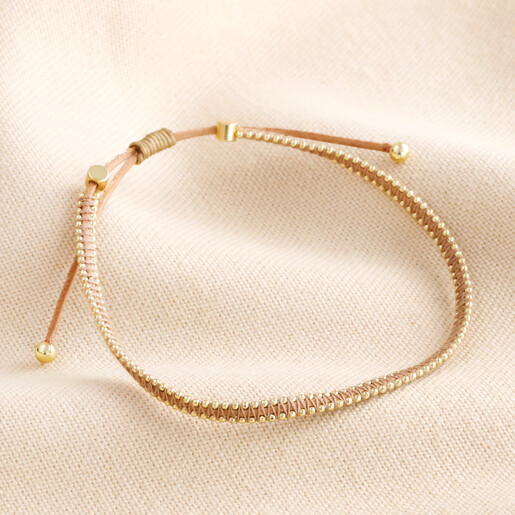 Leather Pull Cord Beaded Bracelet in Gold on Beige Background