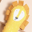 Close up of yellow Trixie Lion Baby Squeaker Toy with corduroy back and soft cotton. Displayed on a beige background.