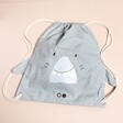 A Dusky Blue Spotty Cotton Bag With a Sweet Shark Face on a Neutral Background