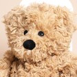 Warmies Junior Brown Curly Bear Microwavable Soft Toy close up on a neutral background