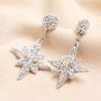 My Doris Mini Silver Star Drop Earrings on beige background