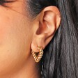 Close Up of Twisted Rope Creole Heart Hoop Earrings In Gold on Model