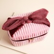 Pink and burgundy washbag on a neutral background