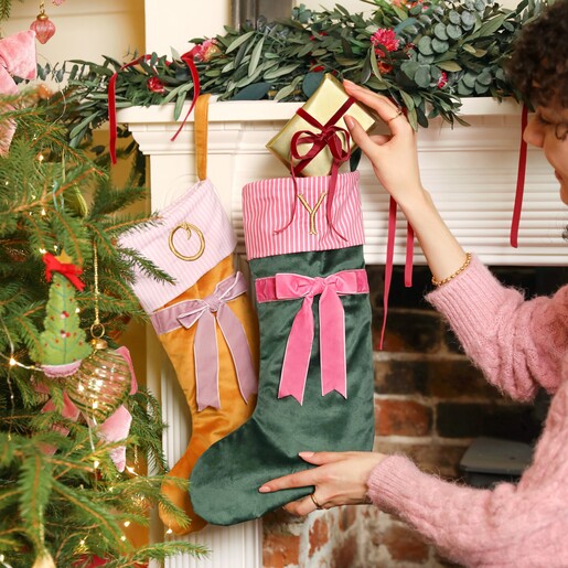 Two stockings Personalised Initial Velvet Bow Stocking on a mantleplace