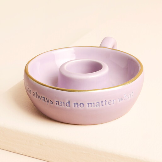 candle holder face on against pale pink background