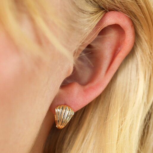 Clam Huggie Hoop Earrings in Gold on a neutral background