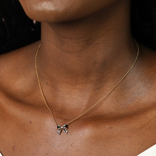 Model Wearing Black Enamel Bow Pendant Necklace in Gold