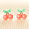 Cherry Stud Earrings against pink background