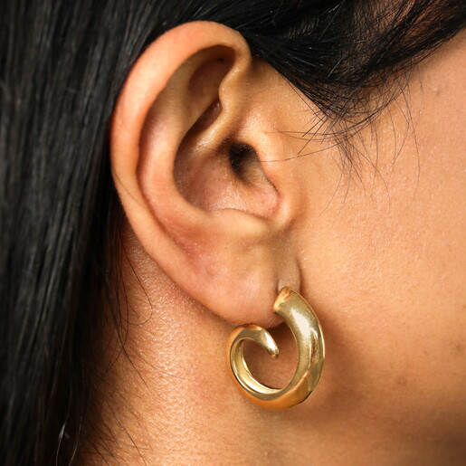 Stainless Steel Swirl Hoop Earrings in Gold on a neutral background