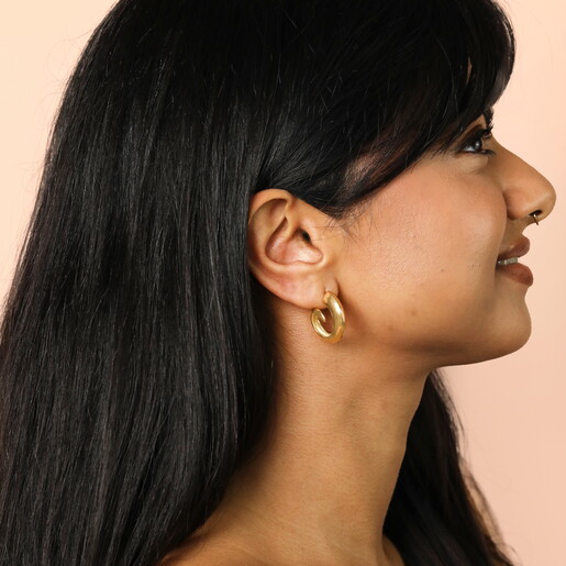 Stainless Steel Swirl Hoop Earrings in Gold on a neutral background