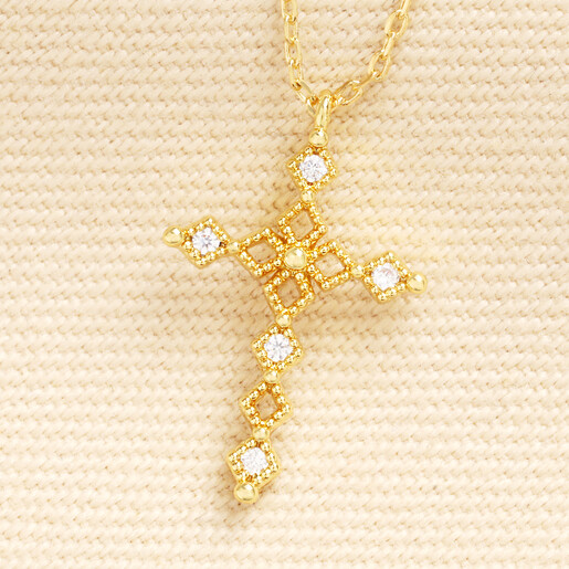 Close up view of the intricate gold lattice cross pendant set with clear crystals